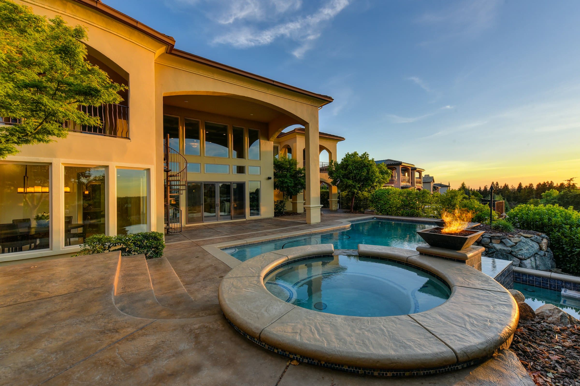 Pool yard at golden hour with stone coping and a privacy enclosure